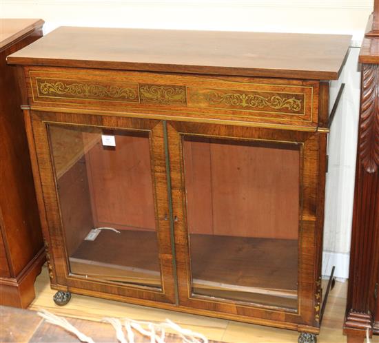 A Regency rosewood low bookcase, inlaid with cut brasswork, enclosed by a pair of glazed doors W.94cm